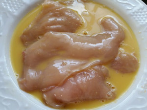 Die Hähnchenfilets trockentupfen und gründlich im Ei baden. Ja, die dürfen ruhig alle gemeinsam baden!