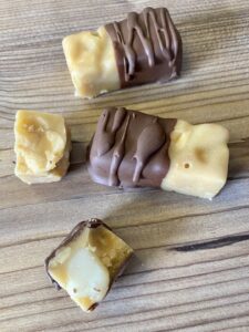 und halb oder ganz in Schokolade tunken. Auf Alufolie geben und kurz fest werden lassen.